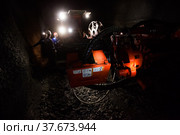 Khromtau, Aktobe region, Kazakhstan - May 06 2012: Gold mine underground gallery. Ore mining machine and engineers. Редакционное фото, фотограф Alexey Rezvykh / Фотобанк Лори