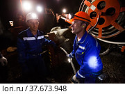 Khromtau, Aktobe region, Kazakhstan - May 06 2012: Gold mine underground gallery. Ore mining machine and engineers. Редакционное фото, фотограф Alexey Rezvykh / Фотобанк Лори