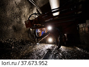 Khromtau, Aktobe region, Kazakhstan - May 06 2012: Ore mining machine and engineers. Gold mine underground gallery. Редакционное фото, фотограф Alexey Rezvykh / Фотобанк Лори