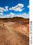 Walking draglines and excavator. Color aluminium ore quarry steps. Bauxite open cast (open-cut) mining. Blue sky with clouds background. Vertical photo. Стоковое фото, фотограф Alexey Rezvykh / Фотобанк Лори