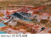 Aluminium ore quarry. Bauxite clay open-cut mining. Quarry steps of various color minerals. Blue quarry lake (left). Стоковое фото, фотограф Alexey Rezvykh / Фотобанк Лори