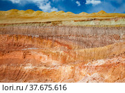 Aluminium ore quarry. Bauxite clay open-cut mining. Texture of mineral cutting with excavator bucket. Color layers of terrain. On blue sky with clouds background. Стоковое фото, фотограф Alexey Rezvykh / Фотобанк Лори