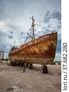Mangystau, Kazakhstan - May 19, 2012: Old rusted steel ship on ship-repairing yard. Caspian Sea, Bautino bay. Grey storm cloudy sky. Стоковое фото, фотограф Alexey Rezvykh / Фотобанк Лори