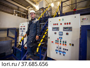 Ekibastuz, Kazakhstan - May 28, 2012. Explosive material production plant for coal quarry mining. Chemical engineer and equipment control panel. Focus on right panel. Редакционное фото, фотограф Alexey Rezvykh / Фотобанк Лори
