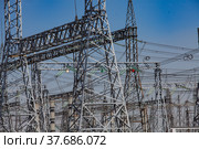 Close-up view of electric transformer substation. Distribution station of electricity. Blue sky background. Стоковое фото, фотограф Alexey Rezvykh / Фотобанк Лори