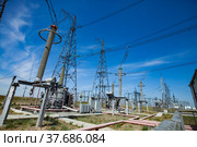 Electric towers and insulators of transformer substation. Distributing station of electricity. Blue sky background. Стоковое фото, фотограф Alexey Rezvykh / Фотобанк Лори