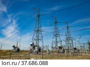 Electric transformer substation. Distribution station of electricity. Blue sky background. Стоковое фото, фотограф Alexey Rezvykh / Фотобанк Лори