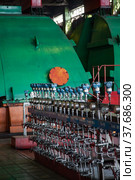 Aksu, Pavlodar region, Kazakhstan - May 29, 2012: Aksu steam power station workshop. Set of gauges. Green cover of steam turbine on background. Редакционное фото, фотограф Alexey Rezvykh / Фотобанк Лори