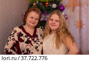 Радостные бабушка и внучка около новогодней елки в новогодние праздники (2022 год). Редакционное фото, фотограф Мария / Фотобанк Лори