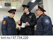 Офицер полиции инструктирует казаков по несению службы по охране общественного порядка на территории железнодорожного вокзала в Белгороде (2017 год). Редакционное фото, фотограф Free Wind / Фотобанк Лори