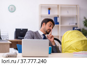 Young male employee looking after new born at workplace. Стоковое фото, фотограф Elnur / Фотобанк Лори