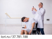 Old male doctor psychiatrist examining young disabled patient. Стоковое фото, фотограф Elnur / Фотобанк Лори