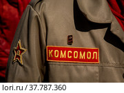 Крупным планом куртка комсомольца с комсомольским значком на лацкане и надписью комсомол во время патриотических мероприятий в городе Москве (2022 год). Редакционное фото, фотограф Николай Винокуров / Фотобанк Лори