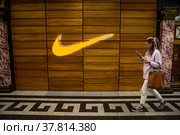 Логотип американской компании спортивной одежды Nike у магазина бренда в торговом центре Охотный ряд города Москвы, Россия (2022 год). Редакционное фото, фотограф Николай Винокуров / Фотобанк Лори
