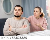 Woman apologizing to offended boyfriend after quarrel at home. Стоковое фото, фотограф Яков Филимонов / Фотобанк Лори