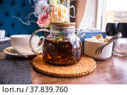 Черный листовой чай в запотевшем прозрачном чайнике, сахарница и чашке на столе в кафе. Стоковое фото, фотограф Диана Лукьянова / Фотобанк Лори