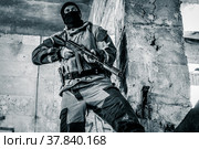 Вооружённый солдат в защитной маске в разрушенном здании (2021 год). Редакционное фото, фотограф Виталий Михайлюк / Фотобанк Лори