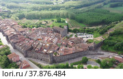 Panoramic aerial view of medieval walled village of Hostalric with reddish tiled roofs of residential buildings on summer day, Catalonia, Spain. Стоковое видео, видеограф Яков Филимонов / Фотобанк Лори