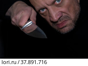 Агрессивный мужчина с ножом в руках. Убийца в темноте. Псих с оружием. Стоковое фото, фотограф Виталий Михайлюк / Фотобанк Лори
