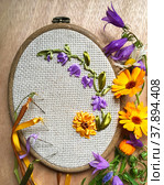 The process of hand embroidery of floral ornament with calendula and bluebells flowers and the needles with satin ribbons (embroidery was made by the author of the photo) Стоковое фото, фотограф Виктория Катьянова / Фотобанк Лори