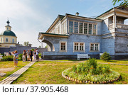 IRKUTSK, RUSSIA - July 06, 2019: The guide tells a group of tourists about the history of the Volkonsky manor house in the courtyard of the Museum of Decembrists on a summer day. Редакционное фото, фотограф Виктория Катьянова / Фотобанк Лори