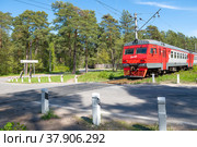 Пригородный электропоезд ЭТ2М-110 у нерегулируемого железнодорожного переезда солнечным майским днем. Сестрорецк (2022 год). Редакционное фото, фотограф Виктор Карасев / Фотобанк Лори