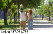 Happy parents holding hands and walking in the green park. Стоковое видео, видеограф Константин Шишкин / Фотобанк Лори
