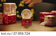 Christmas snowglobe and Christmas gifts on table. Стоковое видео, видеограф Сергей Толмачёв / Фотобанк Лори