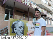 Уличный художник Сергей Юраков расписывает стену центральной библиотеки имени Ф.И. Тютчева в Балашихе (2022 год). Редакционное фото, фотограф Дмитрий Неумоин / Фотобанк Лори