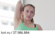 Woman does yoga in the studio - clasps her hands behind her back. Стоковое видео, видеограф Константин Шишкин / Фотобанк Лори
