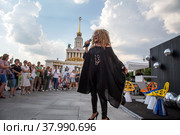 Артистка в образе Аллы Пугачевой выступает перед зрителями на Главной аллее ВДНХ во время празднования дня рождения выставки в городе Москве, Россия (2022 год). Редакционное фото, фотограф Николай Винокуров / Фотобанк Лори