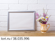 Silver landscape frame mockup with chamomile and purple flowers in golden pitcher. Стоковое фото, фотограф TasiPas / Фотобанк Лори