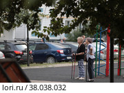 Пожилые женщины со скандинавскими палками смотрят на граффитиста в рамках фестиваля "Культурный код 2022" в Балашихе. Редакционное фото, фотограф Дмитрий Неумоин / Фотобанк Лори