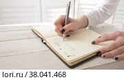 The girl writes in a notebook and counts on a calculator, making lists of plans. Стоковое видео, видеограф Катерина Белякина / Фотобанк Лори