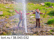 tourists travelers on the banks of the Ay river near the high fountain of a geyser on a summer sunny day. Стоковое фото, фотограф Акиньшин Владимир / Фотобанк Лори