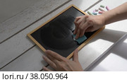 A woman erases a face on a children's blackboard with a smile on the table. Стоковое видео, видеограф Катерина Белякина / Фотобанк Лори