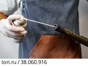 Close up of a man in apron lubricates the mechanism of the weapon with oil. Стоковое фото, фотограф Сергей Толмачёв / Фотобанк Лори