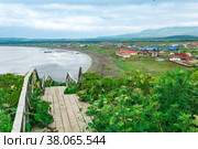 View of the bay of Yuzhno-Kurilsk on the island of Kunashir from a high cape, in the foreground a wooden sidewalk with a ladder. Стоковое фото, фотограф Евгений Харитонов / Фотобанк Лори