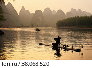 The Li River (Lijiang River) with karst hills along the shores at sunset. Traditional vintage way of fishing with cormorants on bamboo raft. Beautiful unusual Chinese landscape (2011 год). Стоковое фото, фотограф Виктория Катьянова / Фотобанк Лори