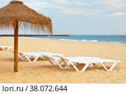 Beautiful sandy deserted beach with an umbrella and deck chairs on the sea shore. Natural sea background. Vilamoura Beach, Algarve, Portugal (2012 год). Стоковое фото, фотограф Виктория Катьянова / Фотобанк Лори