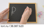 A woman's hand draws the symbols of the ruble and dollar with chalk on the board and a question mark between them, the concept of currency falling. Стоковое видео, видеограф Катерина Белякина / Фотобанк Лори