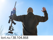 Capitulating soldier sniper rifles with an optical sight in man`s hands give up winter day blue sky (2022 год). Редакционное фото, фотограф Camptoloma / Фотобанк Лори