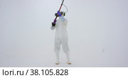 Man in white chemical protection suit holds metal detector. Стоковое видео, видеограф Aleksey Kidisyuk / Фотобанк Лори