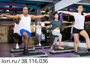 Group of people working out with steppers in fitness center. Стоковое фото, фотограф Яков Филимонов / Фотобанк Лори