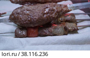 Close-up of ready lumpy kebab with tomato and ground kebab. Стоковое видео, видеограф Aleksey Kidisyuk / Фотобанк Лори