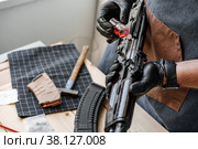 Close up of a man in apron lubricates the mechanism of the weapon with oil. Стоковое фото, фотограф Сергей Толмачёв / Фотобанк Лори