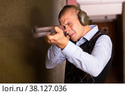 Focused man aiming shotgun at target in shooting range. Стоковое фото, фотограф Яков Филимонов / Фотобанк Лори