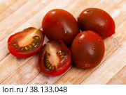 Whole and sliced ripe brownish mini tomatoes on table. Стоковое фото, фотограф Яков Филимонов / Фотобанк Лори