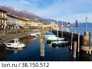 Cannobio waterfront along Lago Maggiore with boats in harbour on winter day (2022 год). Редакционное фото, фотограф Яков Филимонов / Фотобанк Лори