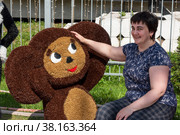 Женщина знакомится с Чебурашкой в сквере у вокзала станции Чудово. Новгородская область (2021 год). Редакционное фото, фотограф Александр Щепин / Фотобанк Лори